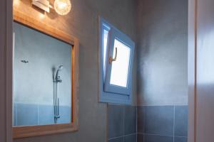 a bathroom with a shower and a mirror at Earino Suites and Villa in Akrotiri