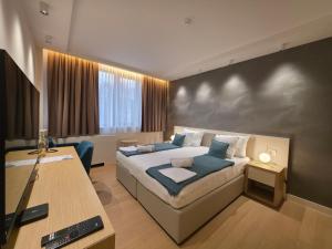 Vrnjačka BanjaにあるApartmani Zepterme by CENTRALのベッドと机があるホテルの部屋