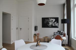 Una sala de estar blanca con una mesa y sillas. en The Antwerp Cathedral suite first floor, en Amberes