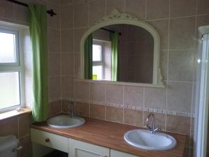 a bathroom with two sinks and a mirror at Rosswood House in Donegal +27 photos