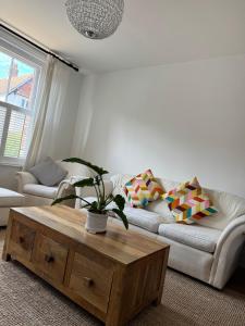 a living room with a couch and a coffee table at Marchwood House 4 bedroom sleeps 8 in the Village 10 mins walk to the beach in Bembridge