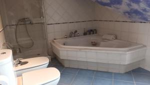 a bathroom with a tub and a toilet and a sink at Casa San Roque in Villanueva de Arosa +19 photos
