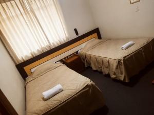 a hotel room with two beds and a window at Hostal LATlNO in Arequipa