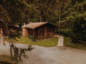 une petite cabane en bois au milieu d'une forêt dans l'établissement Chalé Sanga, à Jaraguá do Sul