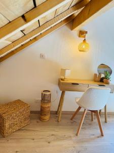 an attic room with a desk and a chair at Le domaine d Isa maison Elor in Vienville