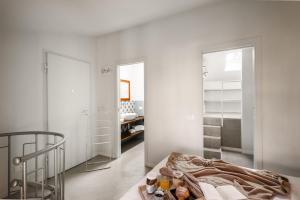 a white room with a bed and a mirror at La casa sulla Terrazza in Sarnico