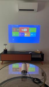 a room with a glass table and a tv on a wall at Le petit Mas in Nîmes