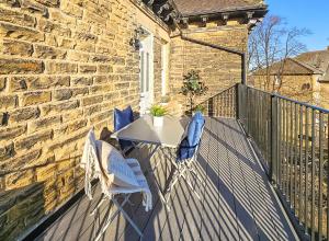 a patio with two chairs and a table on a balcony at Granby Gem: Exquisite 3-Bed Flat in Harrogate