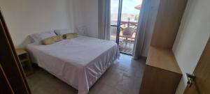 a bedroom with a bed with a view of a balcony at Apartamento aconchego Atalaia in Luis Correia