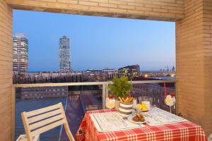 a table on a balcony with a view of a city at Enjoybcn Marina Apartment in Barcelona