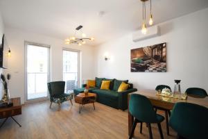a living room with a green couch and a table at Apartament POD SŁOŃCEM BAŁTYKU w Perle Mórz-Ustronie Morskie Sianożęty in Sianozety
