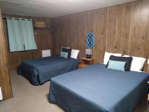 2 letti in una camera con pannelli in legno di Crawford Motel a Springfield
