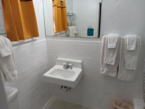 un bagno bianco con lavandino e specchio di Crawford Motel a Springfield