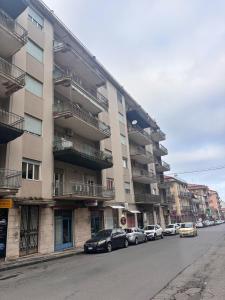 eine Reihe von Autos parkten vor einem Wohnhaus in der Unterkunft Stanza 30 euro per 2 ore Giarre in Giarre