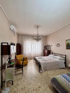 ein Schlafzimmer mit einem Bett und einem Kronleuchter in der Unterkunft Stanza 30 euro per 2 ore Giarre in Giarre