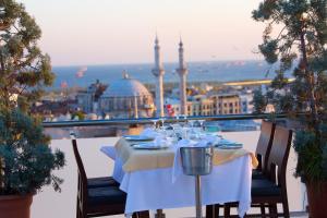a table on a balcony with a view of a city at Mosaic Hotel Old City -Special Category in Istanbul