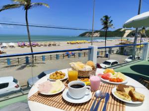 a table with breakfast food and a view of the beach at Ponta Negra Suites & Apart in Natal