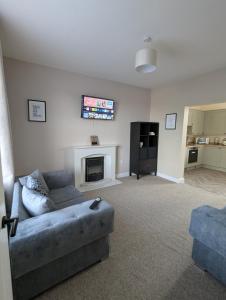a living room with a couch and a fireplace at Hilltop Retreat at Banktop in Southowram