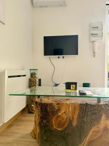 a glass table on top of a tree stump in a room at Le patio, T2 en centre ville in Montauban +7 photos
