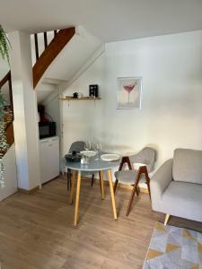 a living room with a glass table and chairs at Le patio, T2 en centre ville in Montauban
