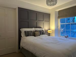 a bedroom with a large bed with a large headboard at 2 bed period cottage sleeps 4 in central Crickhowell in Crickhowell