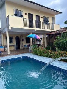 a house with a swimming pool and an umbrella at Paraíso no Chapéu Virado in Belém