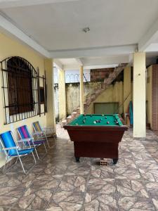a pool table in a room with chairs and a staircase at Paraíso no Chapéu Virado in Belém