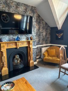 Una sala de estar con chimenea y un sofá. en Pheasant View at Number 35, en Llandudno
