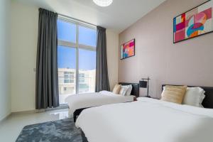 a hotel room with two beds and a large window at Cozy 2BR Villa in Damac Hills 2 by deleguest in Dubai