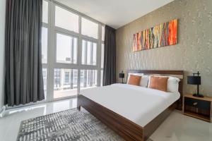 a bedroom with a large bed and a large window at Cozy 2BR Villa in Damac Hills 2 by deleguest in Dubai