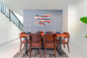 a dining room with a table with chairs and a painting at Cozy 2BR Villa in Damac Hills 2 by deleguest in Dubai +9 photos