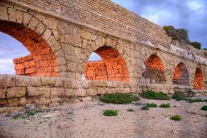 an old brick bridge with three arches on it at Caesarea Vacation Rooms in Caesarea