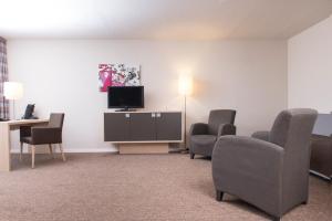a living room filled with furniture and a tv at Mercure Bonn Hardtberg in Bonn