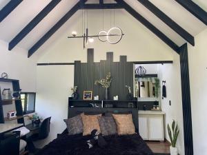 a bedroom with a large black bed and a mirror at Cabaña Lambrusco - La Cava Lodge in Medellín