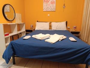 a bed with blue sheets and white towels on it at Πλάτανος Στούντιο ΙΙΙ PLATANOS STUDIO III in Mytilene