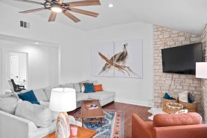 a living room with a couch and a tv at 6 BR Hot Tub King Beds Game Room Tiled Showers in Fredericksburg