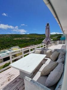 a white couch and a table on a deck at Sea Rose Cottage with Hot Tub in Dido Valley +32 photos