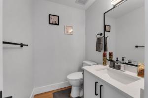 biała łazienka z toaletą i umywalką w obiekcie Your Pleasant stay in 3 bedroom House in Saddle-Ridge w mieście Calgary +12 zdjęć