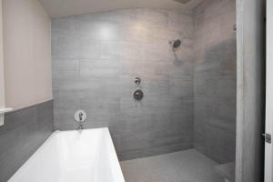Ένα μπάνιο στο Tiled Shower Walk to Main Kitchenette Smart TV