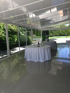 two tables in a room with glass walls at Hotel Barreiro in Leira