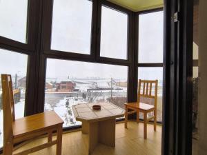 a table and a chair in a room with a large window at Pensiunea Daria in Căşeiu
