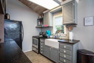 una cocina con fregadero y refrigerador en Kitchen Walk-in Shower One block off Main, en Fredericksburg