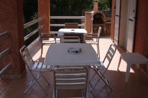 un tavolo e delle sedie seduti su un patio di Villa individuelle avec jardin a Sartène Altre 13 foto