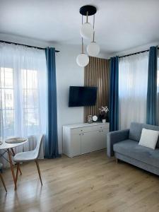Una sala de estar con un sofá azul y una mesa. en Podmiejska 16, en Łódź