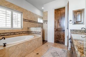 La grande salle de bains est pourvue d'une baignoire et d'une fenêtre. dans l'établissement King Beds Hot Tub On 290 Large Estate Kitchen, à Fredericksburg