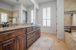 une salle de bain avec deux lavabos et un grand miroir dans l'établissement King Beds Hot Tub On 290 Large Estate Kitchen, à Fredericksburg
