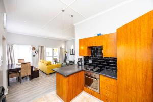 a kitchen with wooden cabinets and a living room at Modern Executive Unit in East London