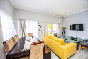 a living room with a yellow couch and a table at Modern Executive Unit in East London