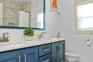 baño con armarios azules y espejo en Just Beachy by Pristine Properties Vacation Rentals, en Mexico Beach 36 fotos más