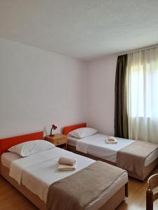 a hotel room with two beds and a window at Rooms Džeba in Međugorje